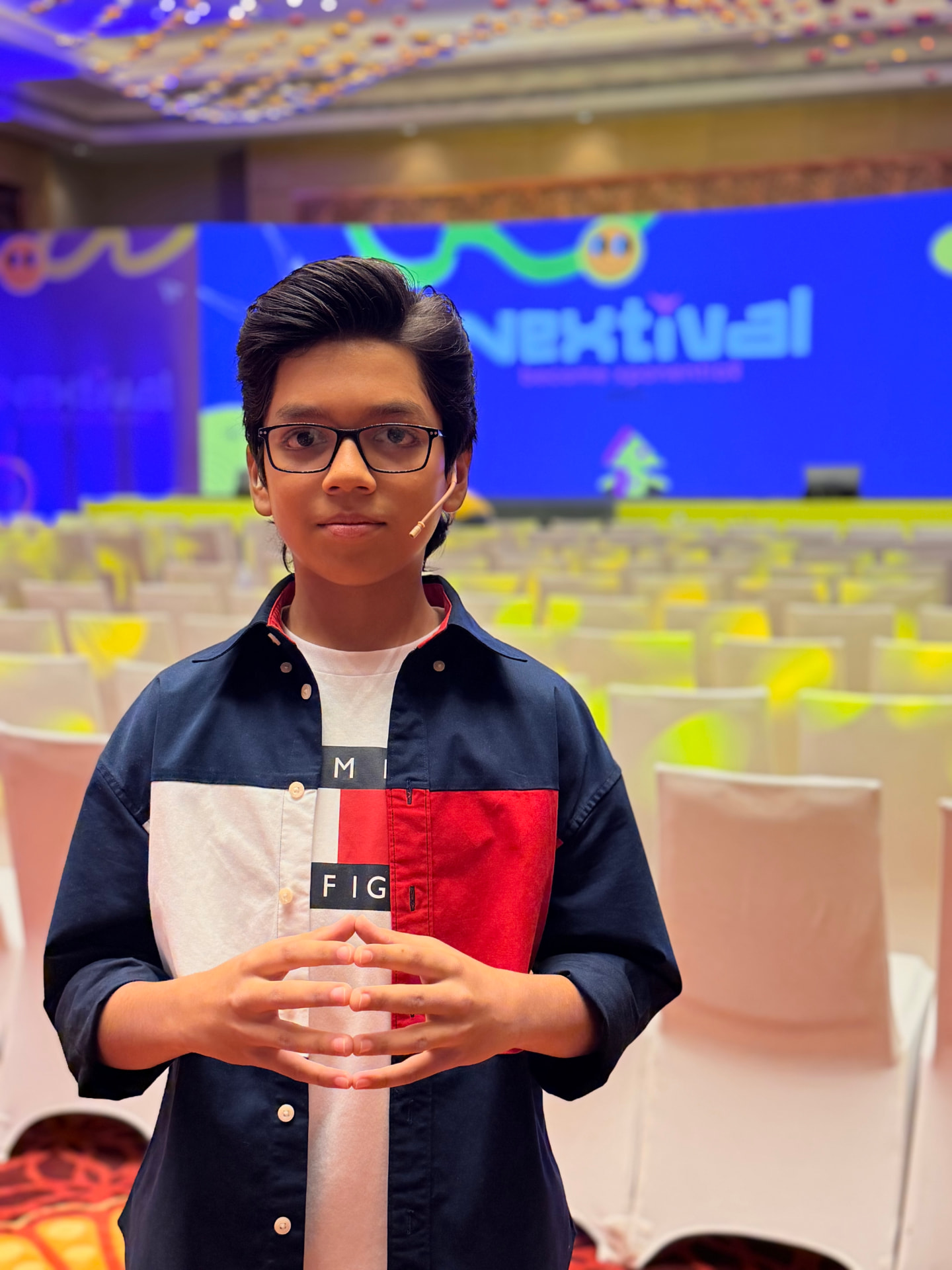 Rishabh Rajsekar on stage at Nextival, speaking to a hall of teens